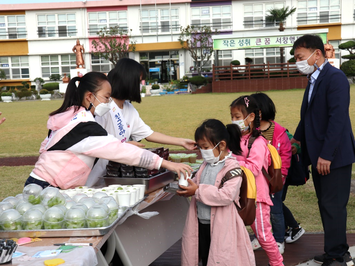 고학년 학생들이 아침대용식(절편), 과일(샤인머스캣), 쌀음료(식혜)를 나눠 주고 있다.