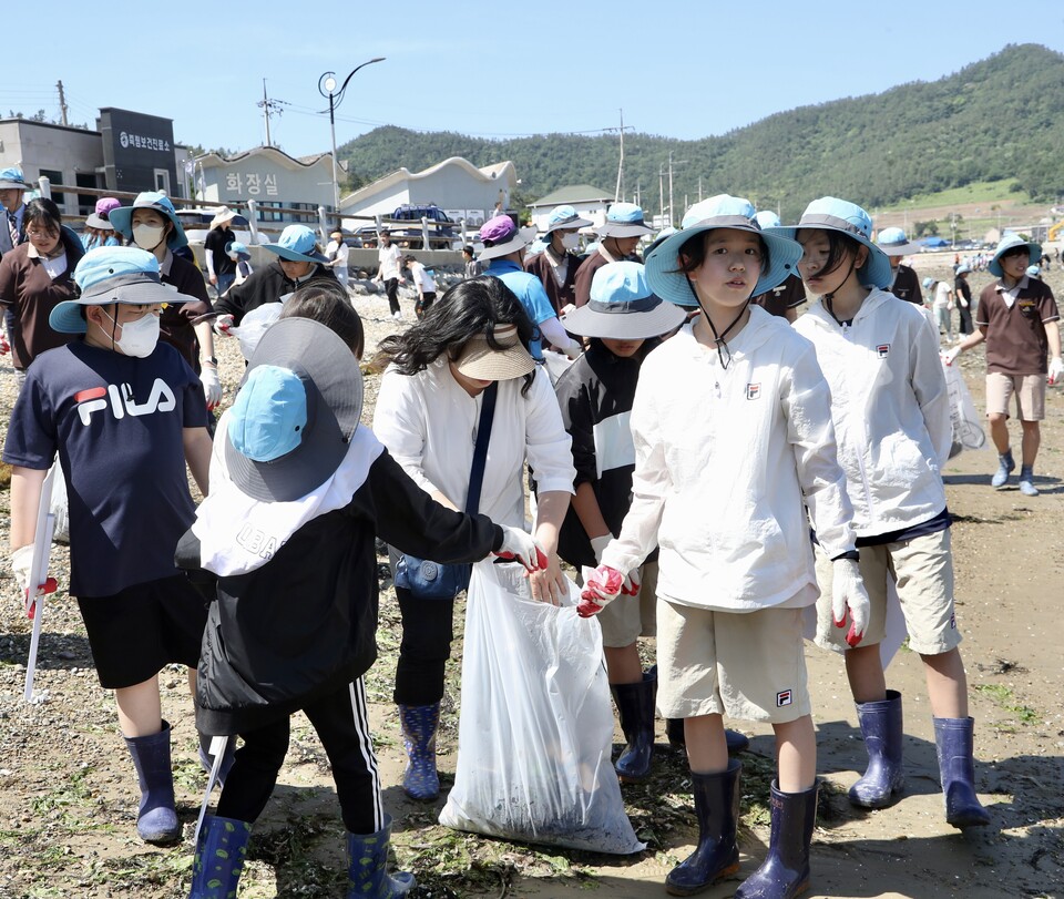 전남교육 가족들이 5월 31일 진도군 임회면 죽림 어촌마을 앞 바닷가에서 ‘공생의 바닷길’ 공동실천 선포식을 마친 뒤 정화활동을 하고 있다.